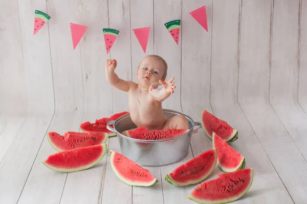 Una bambina di un anno fa un bagno con anguria. — Foto Stock