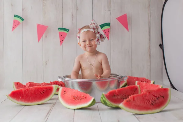 Una bambina di un anno fa un bagno con anguria. — Foto Stock