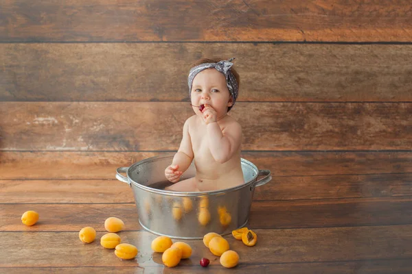 Ein Jahr altes Mädchen badet mit Früchten. — Stockfoto