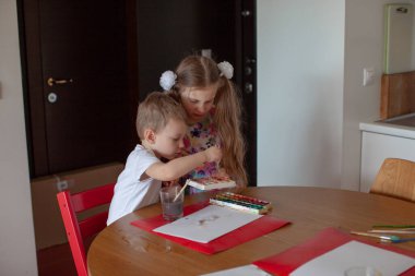 Yedi yaşında bir kız ve üç yaşında bir oğlan. Modern mutfak iç mimarisi. 