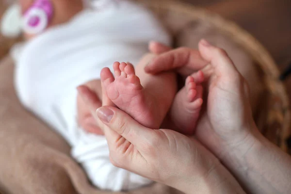 Neugeborene Babyfüße in den Händen des Vaters. — Stockfoto