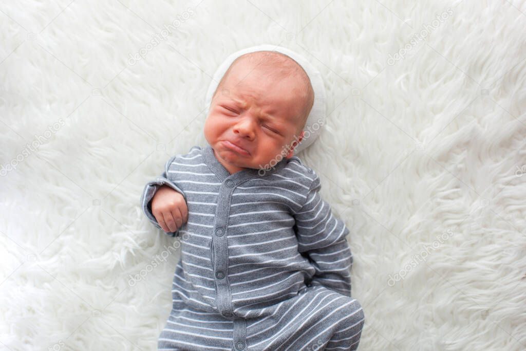 Newborn baby boy. Portrait of a little boy on white fur.