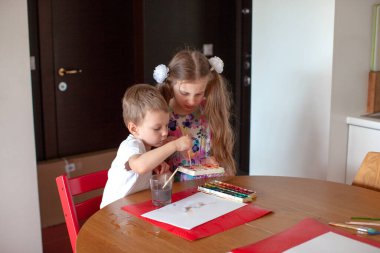 Yedi yaşında bir kız ve üç yaşında bir oğlan. Modern mutfak iç mimarisi. 