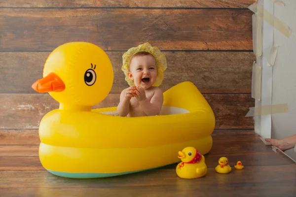 한 살된 여아가 목욕을 한다. 노란 오리와 함께. 로열티 프리 스톡 사진