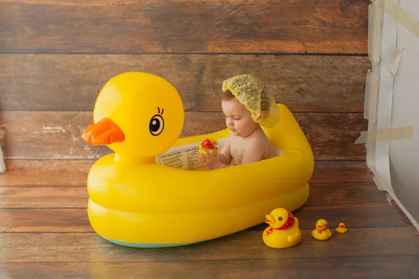 One year old baby girl takes a bath. With yellow duck. — Stock Photo, Image