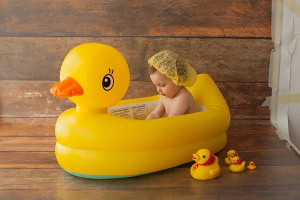 One year old baby girl takes a bath. With yellow rubber duck. — Stock Photo, Image
