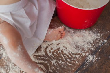 Ahşap arka planda küçük bir bebek şef. Önlükle. Kapatın. Makro fotoğraf. 