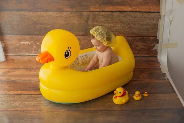 One year old baby girl takes a bath. With yellow rubber duck. — Stock Photo, Image