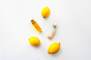 Limon esaslı yağ ve kozmetik serumu beyaz arka planda, üst tarafta, düz yerde. Doğal kozmetik konsepti,