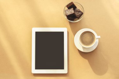 Not defteri, kahve fincanı ve çikolatalı kek. Rahat bir iş yeri, ev konseptinde çalışmak