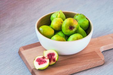 Tahtada incir olan bir kase, yumuşak odaklı.