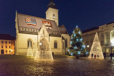 Hırvatistan 'ın başkenti Zagreb' in yukarısındaki St. Marks Meydanı 'ndaki Saint Marks Kilisesi önünde aydınlatılmış Noel ağaçları