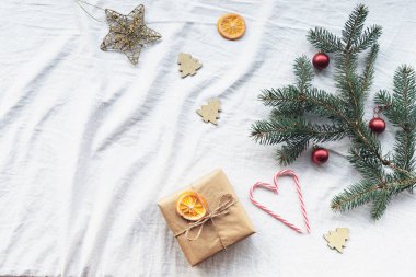 Hediye kutusu, köknar dalları, Noel süslemeleri, çubuk şekerler, kurutulmuş portakallar. Üst görünüm, düz görünüm, kopyalama alanı.