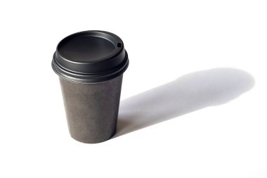 Tek kullanımlık kahve fincanı beyaz masada, keskin gölgeler. Beyaz arkaplanda izole