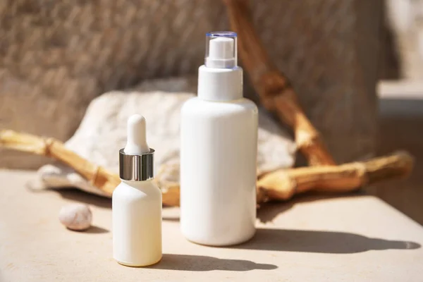 White cosmetic bottles with tonic and serum. Natural cosmetics concept, close up
