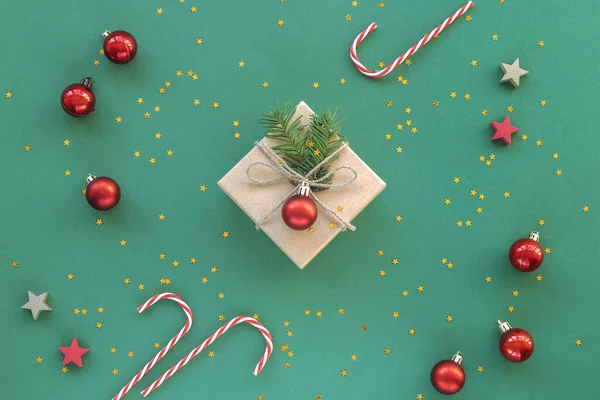 Weihnachtsgeschenk Einer Schachtel Mit Konfetti Und Roten Kugeln Auf Grünem — Stockfoto