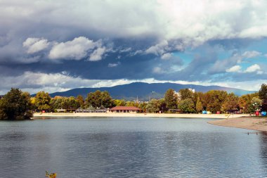 Göl ve dağ bulutlu mavi gökyüzüne karşı. Fırtınalı hava. Jarun Gölü, Zagreb, Hırvatistan.