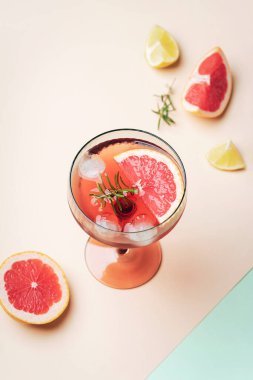 Bardakta greyfurt kokteyli ve bej ve yeşil arka planda biberiye..
