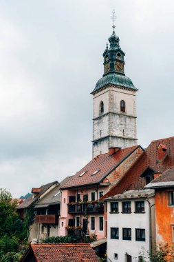 Tarihsel saat kulesi ve Avrupa 'daki eski evlerin çatıları. Skofja Loka, Slovenya.