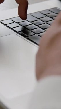 Modern bir bilgisayar klavyesinin detaylarının yakın plan görüntüsü. Genç bir adamın elleri son model bir dizüstü bilgisayarın klavyesinde daktilo kullanıyor..