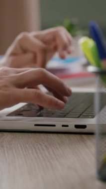 Bilgisayar klavyesine yazı yazan bir çocuğun yan görüntüsü. Ofis masası ve ofisteki dizüstü bilgisayarda çalışan ve internette sörf yapan bir adamın elleri.