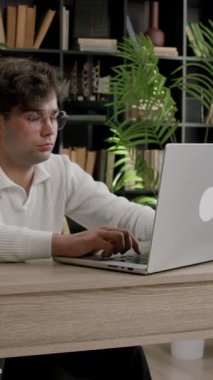 Gözlüklü genç tebeşir gibi çocuk önemli bir proje üzerinde çalışan bir bilgisayarda daktilo yazıyor. Öğrenci internette bir ofisteki dizüstü bilgisayarda bilgi arıyor.