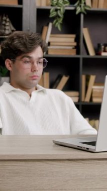 Disappointed student seeing grades from exams at college. Young boy in front of computer nervous and sad participating in online lessons with college colleagues