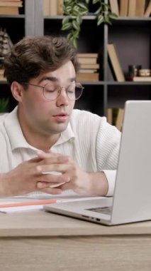 Student amazed and upset when he saw how much information and materials he has to study to prepare for exams. Young boy studying at an office table in front of a laptop