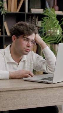 Modern bir ofiste gözlüklü bir çocuk bilgisayarda dikkatle okur, hoşnutsuz ve şaşkın. Genç öğrenci üniversiteye hazırlanıyor ve bir proje üzerinde çalışıyor.