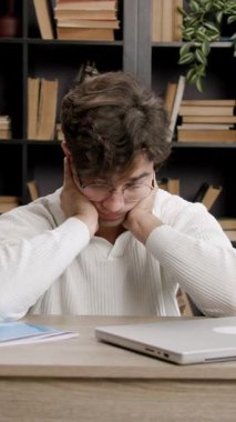 Yorgun genç adam çalışmaya ara verir, gözlerini ve ellerini dinlendirir ve boynunu uzatır. Öğrenim dönemi, dersler, sınavlar öğrenciler için çok zahmetli. Öğrenim kavramı, üniversite, öğrenciler