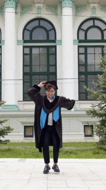 Mezuniyet cübbesi ve şapkası içinde mezuniyet diplomasıyla mutlu ve heyecanlı bir mezuniyet. Gözlüklü çocuk prestijli üniversiteden başarıyla mezun oldu.