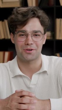 Gözlüklü, kendinden emin genç adam elleriyle kameraya işaret ediyor. Çocuk, projesini uluslararası bir forumda dizüstü bilgisayarın önünde tartışıyor ve sunuyor.