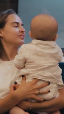 Kadın metroda bebeğini kucaklıyor, ikisi de pencereden dışarı bakıyor, şehir çevresi ve hayat yolculuğu arasında samimi bir an yaşıyor.