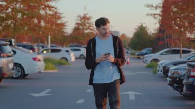 Şehir otoparkındaki kiralık araca erişmek için akıllı telefon uygulaması ile bireysel etkileşimler, modern araba kiralama hizmetlerinin kolaylığını vurguluyor