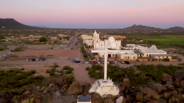 Het witte kruis kijkt uit over Mission San Xavier in Tucson, Arizona. Een drone schot. — Stockvideo