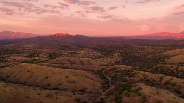 粉红艳丽的落日下，无人驾驶飞机飞越亚利桑那州的山丘 — 图库视频影像