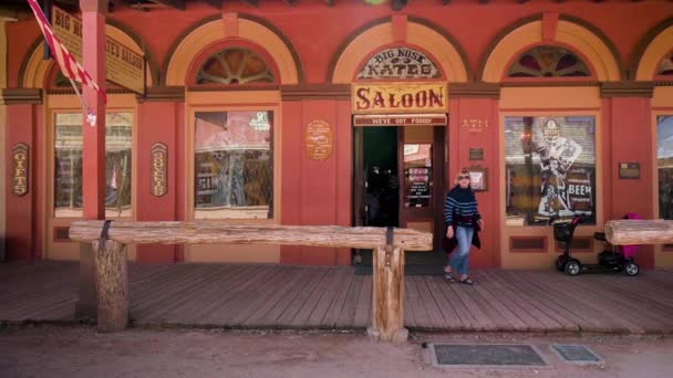 Een vrouwelijke toerist loopt uit de beroemde Big Nose Kate Saloon in Tombstone, Arizona — Stockvideo