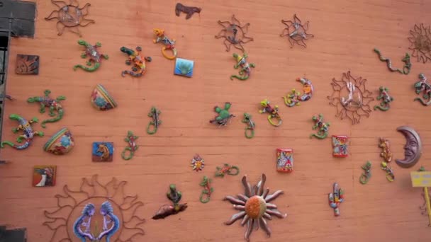 Coloridas obras de arte mexicanas de cerámica colgando de la pared de ladrillo en Tubac, Arizona — Vídeo de stock