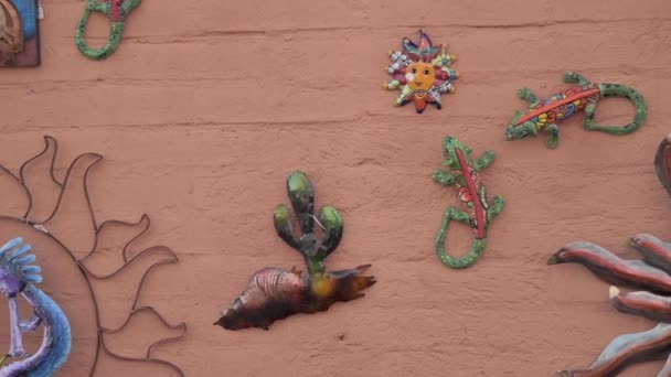 Kleurrijke keramische Mexicaanse kunstwerken opknoping op de stenen muur in Tubac, Arizona — Stockvideo