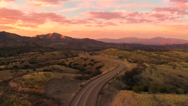 Vista dramática do pássaro dos carros na estrada em montanhas de Arizona no por do sol — Vídeo de Stock