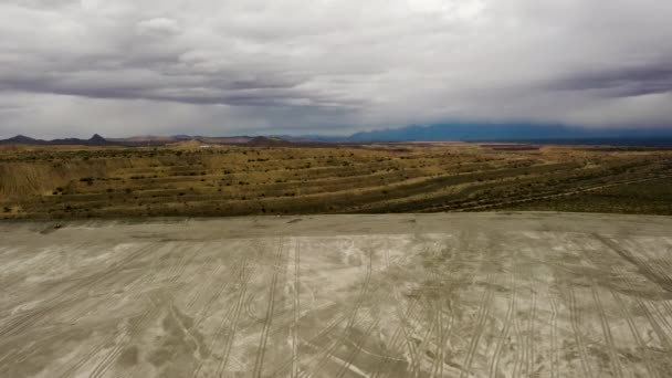Camiones de equipo pesado en el borde de una mina - disparo drone dramático — Vídeos de Stock