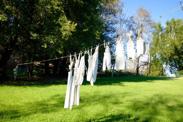 White vintage clothing hangs on clothes line in summer.