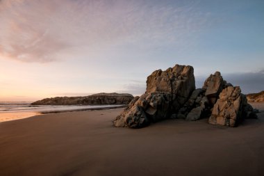 Gün batımında sahilde kayalıklarla deniz manzarası.. 
