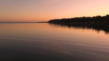 Slhouetted kıyı şeridi ile nehirde barışçıl dalgalanmalar