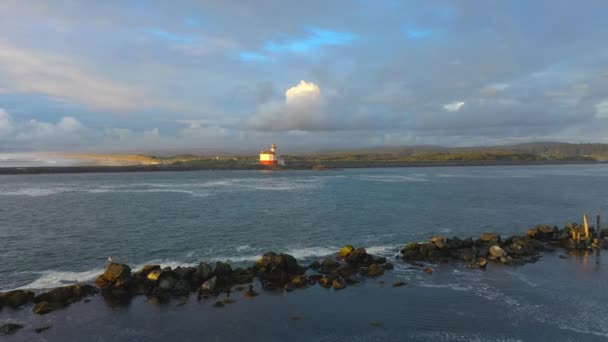 Drone vuela bajo sobre el río en Oregon hacia el faro. — Vídeo de stock