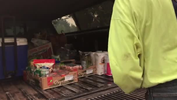 Человек загружает вещи Costco в багажник грузовика. — стоковое видео