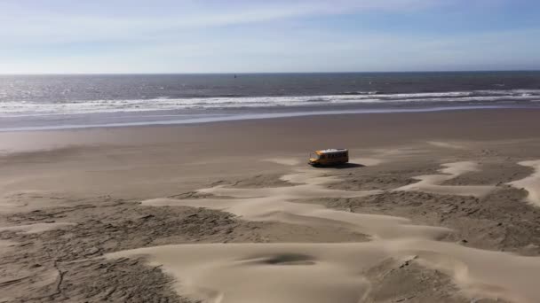 Воздушный дрон с жёлтым фургоном на пляже — стоковое видео