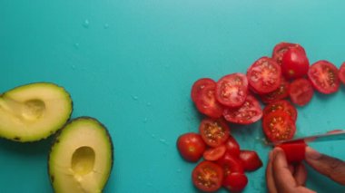 Avokado ve vişneli domates hazırlayan insanların üst görüntüsü