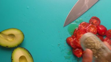 Top view of person hands preparing avocado and tomatoes                 