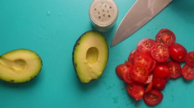 Top view of person hands preparing avocado and tomatoes                 